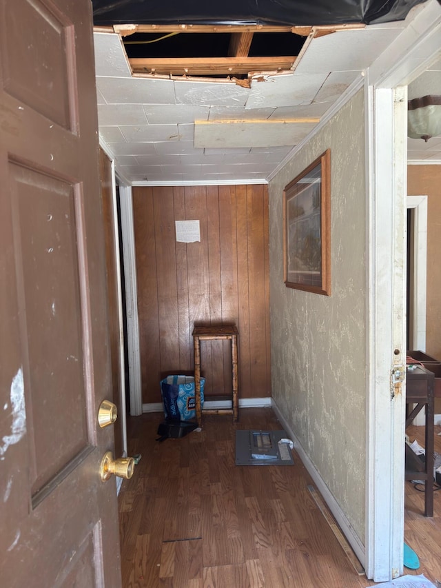 basement featuring baseboards, ornamental molding, and wood finished floors