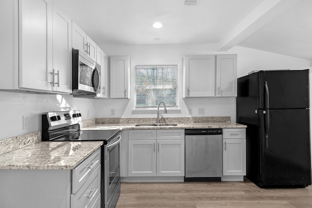 kitchen with white cabinets, sink, light hardwood / wood-style flooring, light stone countertops, and stainless steel appliances