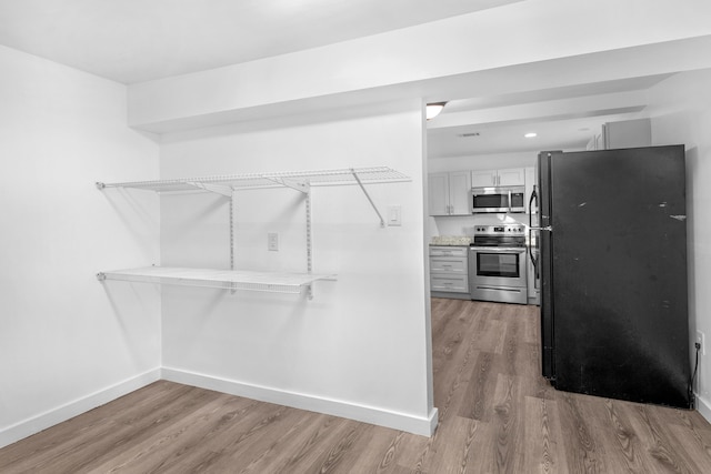 spacious closet with light hardwood / wood-style flooring