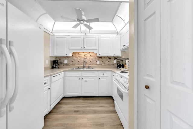 kitchen featuring sink, light hardwood / wood-style flooring, backsplash, white appliances, and white cabinets