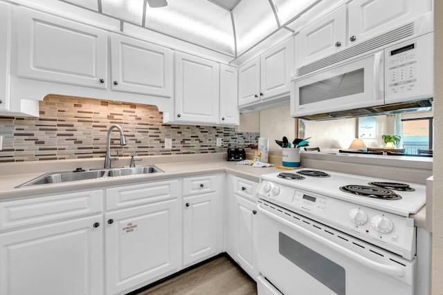 kitchen featuring white appliances, tasteful backsplash, white cabinetry, and sink