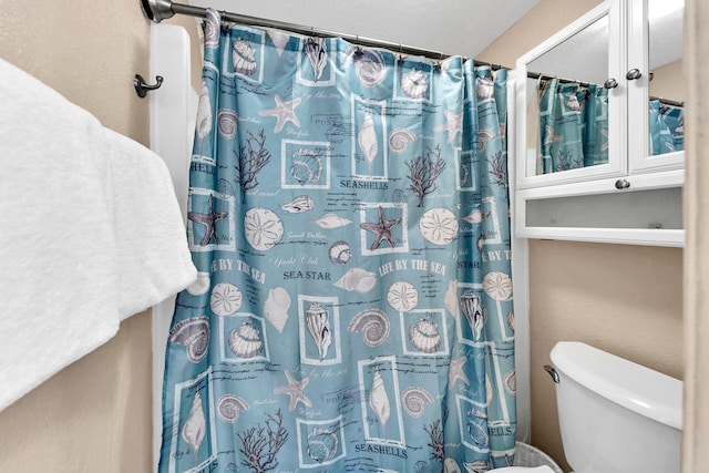 bathroom featuring a shower with curtain and toilet