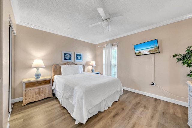 bedroom featuring a textured ceiling, light hardwood / wood-style flooring, ceiling fan, and ornamental molding