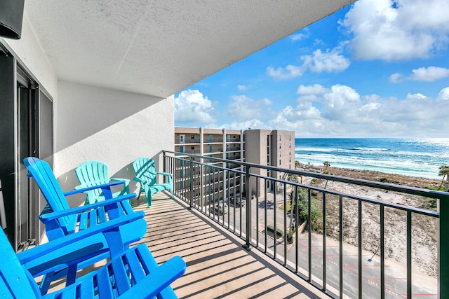 balcony featuring a water view and a beach view