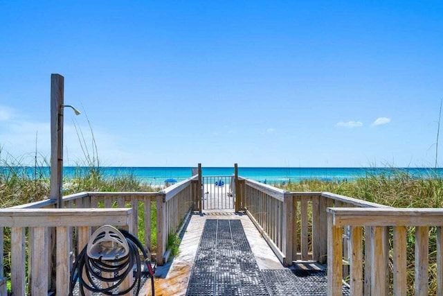 view of community featuring a water view and a beach view