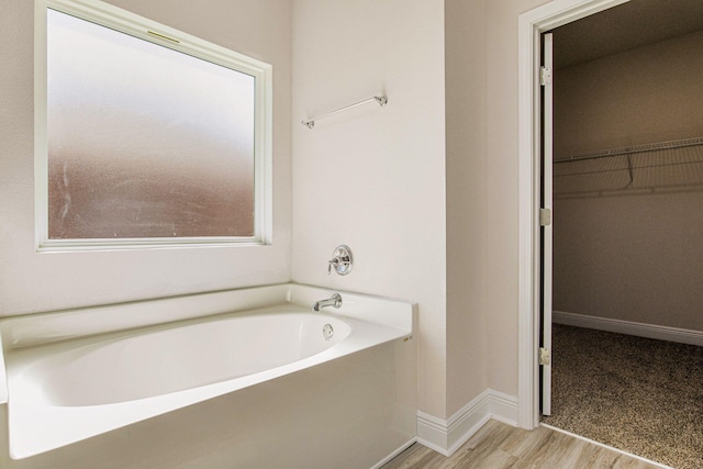 bathroom with hardwood / wood-style floors and a washtub