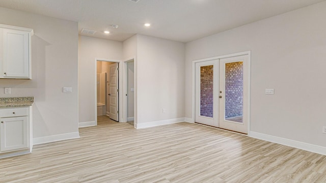 empty room featuring light hardwood / wood-style flooring and french doors