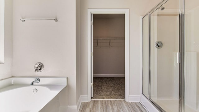 bathroom featuring hardwood / wood-style flooring and plus walk in shower