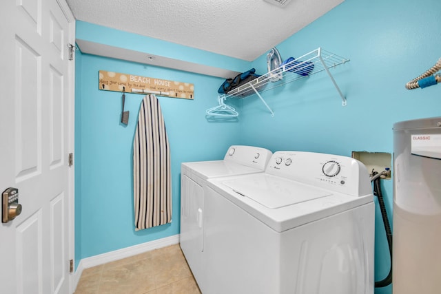 376 Santa Rosa Boulevard Unit 112 - 2Nd Floor, Fort Walton Beach, FL 32548 - washroom featuring washing machine and clothes dryer, water heater, light tile patterned floors, and a textured ceiling