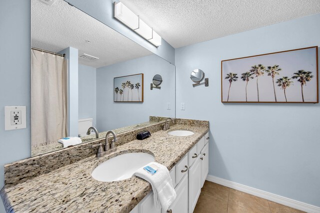 376 Santa Rosa Boulevard Unit 112 - 2Nd Floor, Fort Walton Beach, FL 32548 - bathroom with tile patterned flooring, vanity, a textured ceiling, and toilet