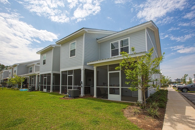 back of house featuring a yard, central AC unit, and a sunroom