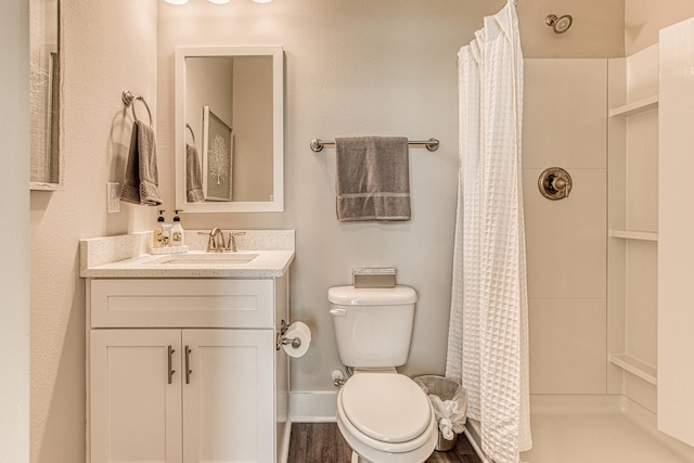 bathroom with toilet, vanity, and walk in shower