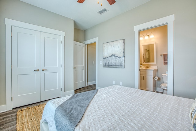 bedroom with ensuite bathroom, ceiling fan, sink, dark hardwood / wood-style floors, and a closet