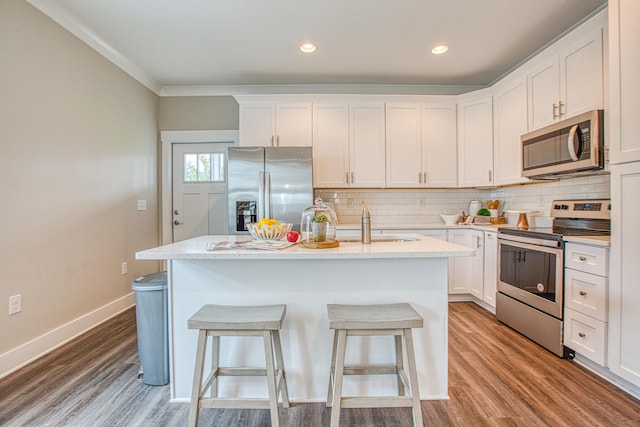 kitchen featuring white cabinetry, a kitchen island with sink, stainless steel appliances, and light stone counters