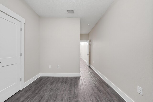 182 N Sand Palm Rd, Freeport, FL 32439 - unfurnished room featuring dark wood-type flooring, baseboards, and a textured ceiling