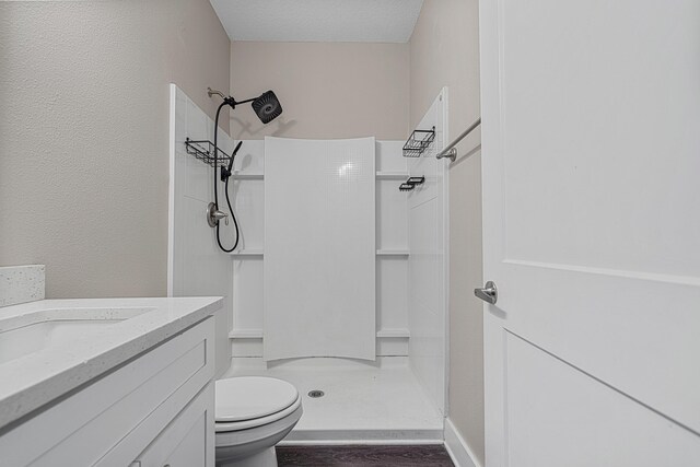 182 N Sand Palm Rd, Freeport, FL 32439 - full bath featuring toilet, a shower stall, vanity, wood finished floors, and a textured ceiling