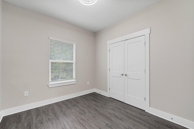 182 N Sand Palm Rd, Freeport, FL 32439 - unfurnished bedroom featuring dark wood-type flooring, baseboards, and a closet