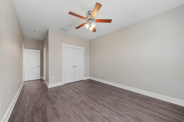 182 N Sand Palm Rd, Freeport, FL 32439 - unfurnished bedroom with dark wood finished floors, baseboards, a closet, and a ceiling fan