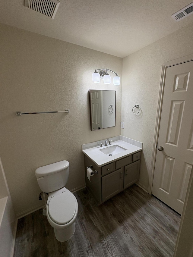 bathroom with vanity, toilet, and wood-type flooring