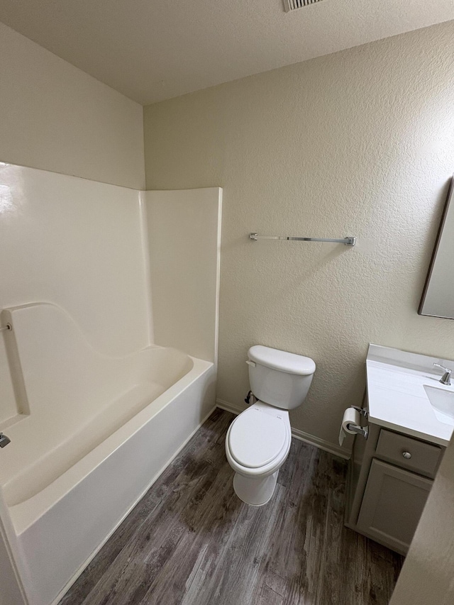 full bathroom with hardwood / wood-style flooring, vanity, toilet, and bathtub / shower combination