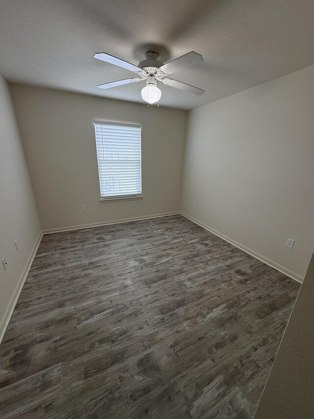 unfurnished room with dark hardwood / wood-style floors and ceiling fan