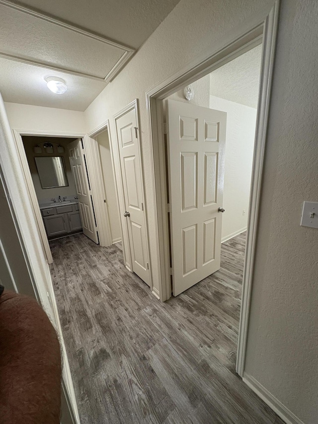 hall featuring hardwood / wood-style floors and a textured ceiling