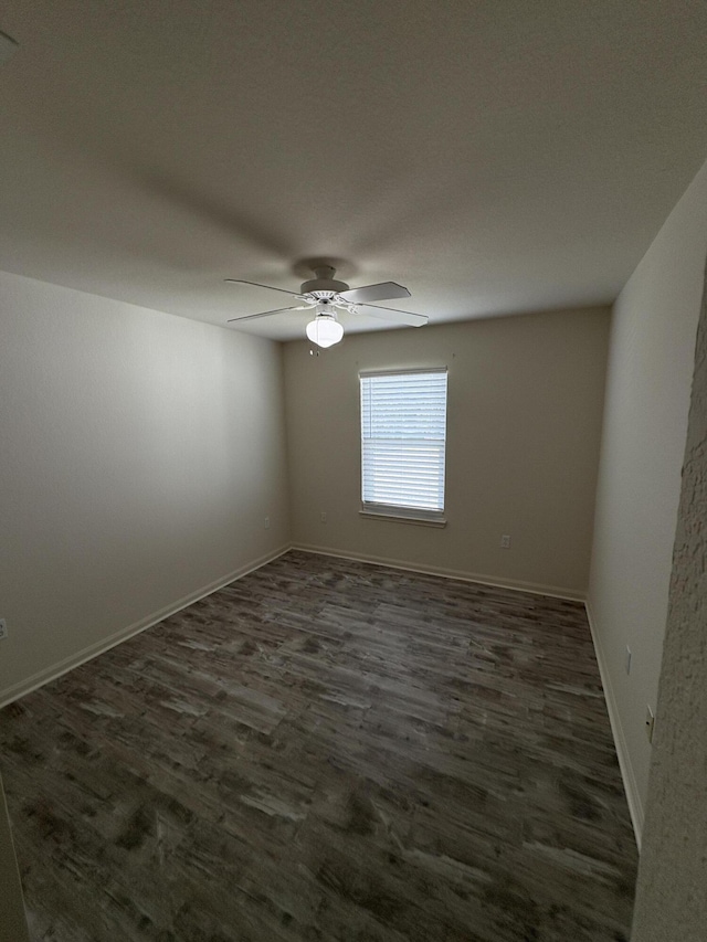 spare room with ceiling fan and dark wood-type flooring