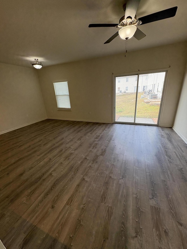 empty room with ceiling fan, dark hardwood / wood-style flooring, and a healthy amount of sunlight