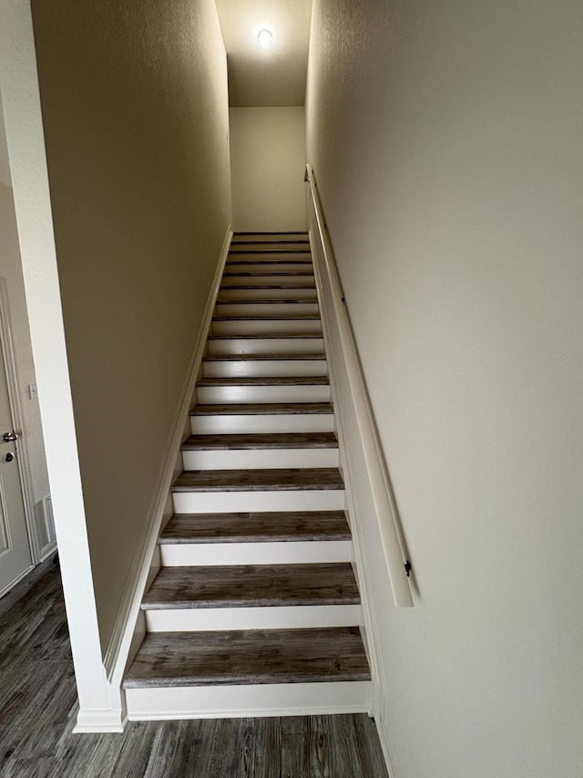 stairway with hardwood / wood-style floors