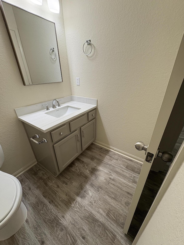 bathroom featuring hardwood / wood-style floors, vanity, and toilet