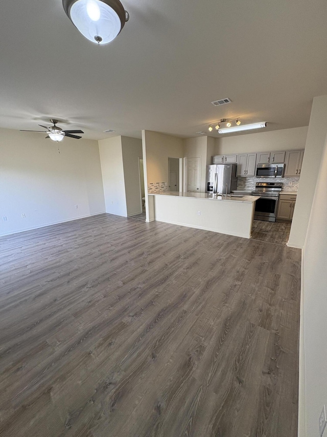 unfurnished living room with ceiling fan and dark wood-type flooring