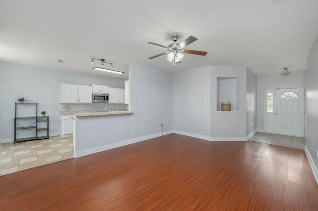 unfurnished living room featuring ceiling fan and light tile patterned floors