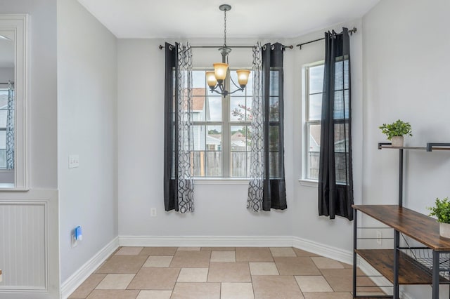 unfurnished dining area with light tile patterned floors, a wealth of natural light, and an inviting chandelier