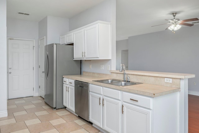 kitchen featuring white cabinets, stainless steel appliances, kitchen peninsula, and sink