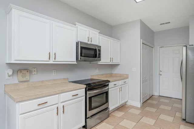 kitchen featuring white cabinetry and appliances with stainless steel finishes