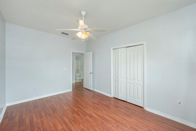 unfurnished bedroom with a closet, ceiling fan, and dark wood-type flooring