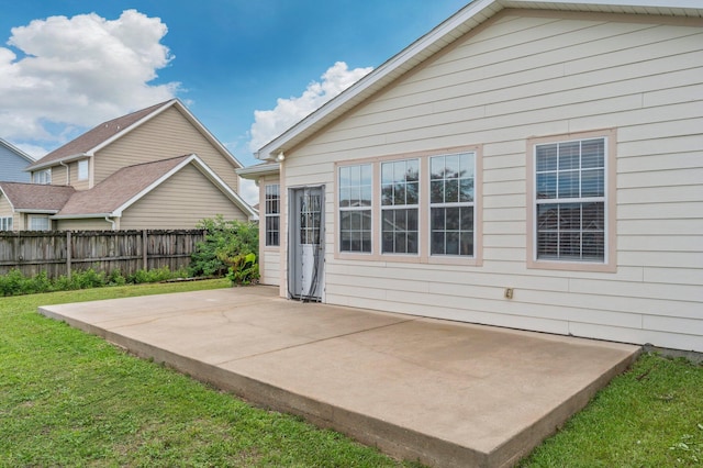 rear view of property featuring a yard and a patio area