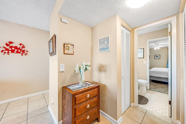 hallway featuring light tile patterned flooring and a textured ceiling