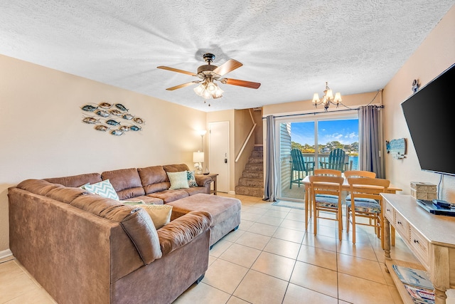 tiled living room featuring a textured ceiling and ceiling fan with notable chandelier