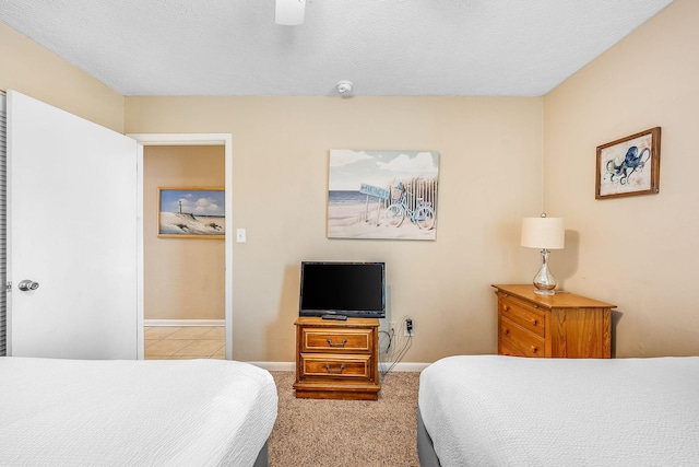 carpeted bedroom featuring a textured ceiling and ceiling fan