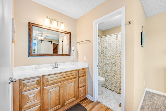 bathroom with vanity, a textured ceiling, toilet, and ceiling fan