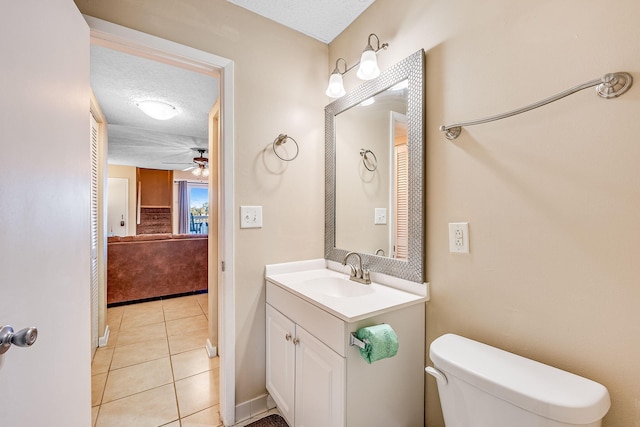 bathroom featuring vanity, a textured ceiling, ceiling fan, tile patterned flooring, and toilet