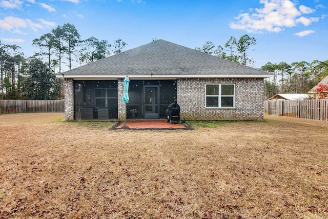 back of house featuring a lawn and a sunroom