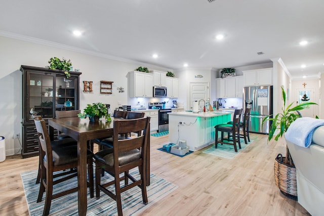 dining space with ornamental molding and light wood-type flooring