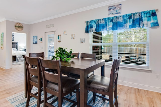 dining area with light hardwood / wood-style floors and crown molding