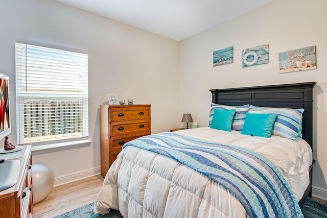 bedroom with light hardwood / wood-style floors and multiple windows