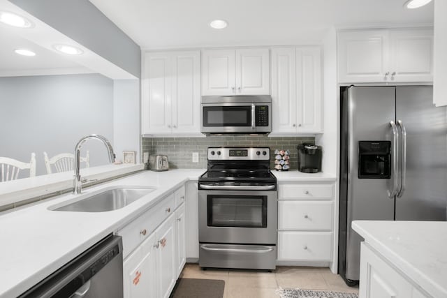 kitchen with white cabinetry, sink, light tile patterned floors, and stainless steel appliances