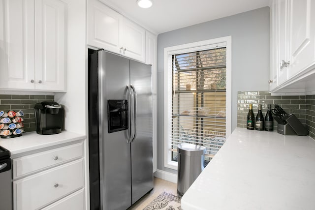 kitchen with white cabinetry, stainless steel refrigerator with ice dispenser, and tasteful backsplash