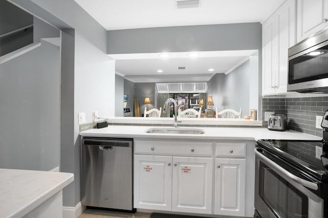 kitchen featuring white cabinets, sink, tasteful backsplash, kitchen peninsula, and stainless steel appliances