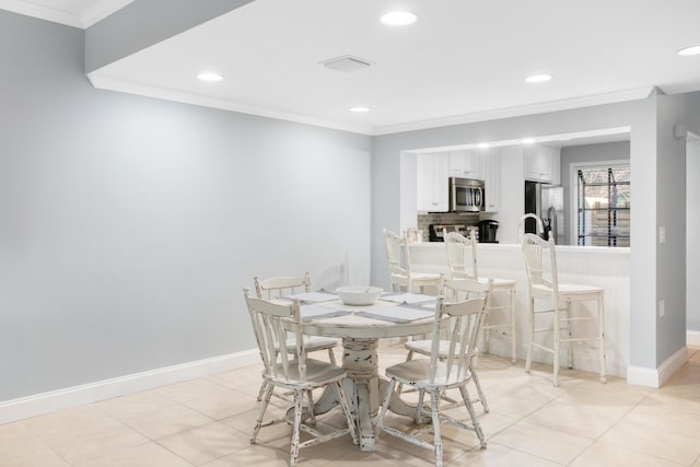 dining room featuring light tile patterned floors and ornamental molding